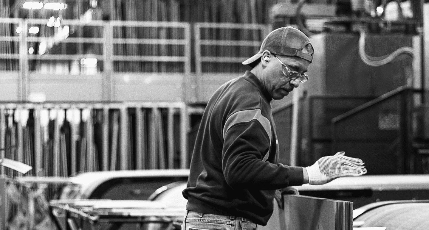 Operator handling laminated sheets on the plant floor in Constantine, Michigan